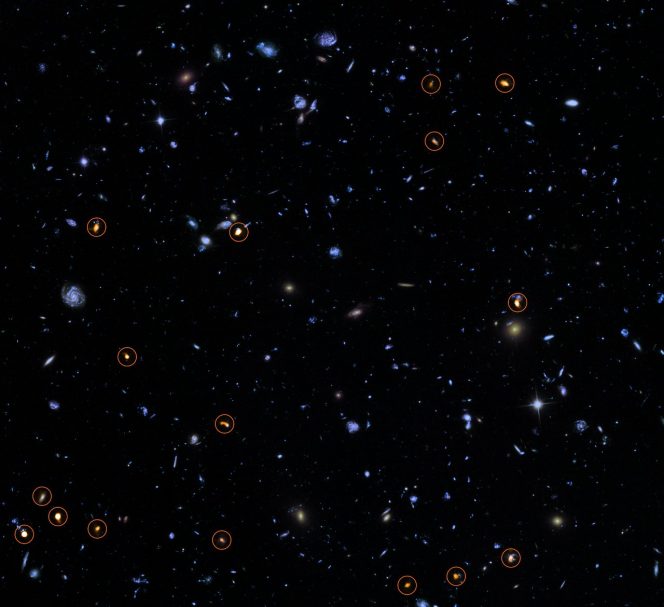 Questa immagine combina una fotografia presa dal telescopio spaziale Hubble della NASA/ESA, sullo sfondo, con una veduta recentissima e molto profonda di ALMA (in arancione, indicata da cerchi). Tutti gli oggetti visti da ALMA sono galassie con un alto tasso di formazione stellare. L'immagine si basa sulla survey ALMA di J. Dunlop e colleghi, che copre l'intero campo HUDF. Crediti: ALMA (ESO/NAOJ/NRAO)/NASA/ESA/J. Dunlop et al. and S. Beckwith (STScI) and the HUDF Team